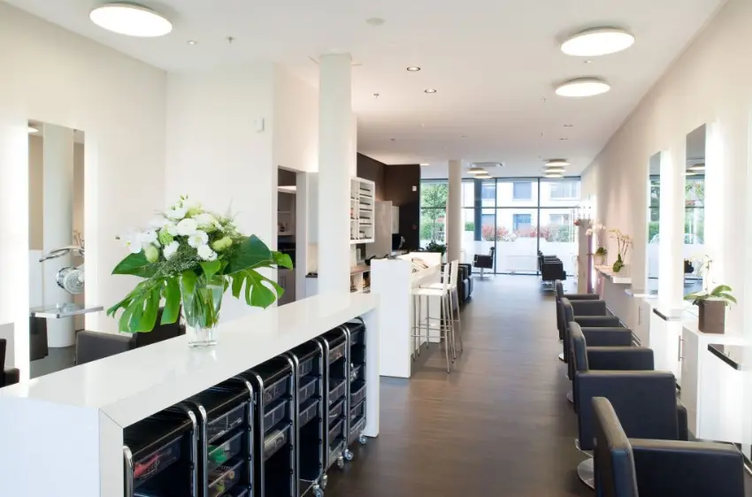 Innenansicht des stilvollen Salons von Coiffeur HAUPTSACHE Sursee mit modernen Arbeitsplätzen und Produktregalen