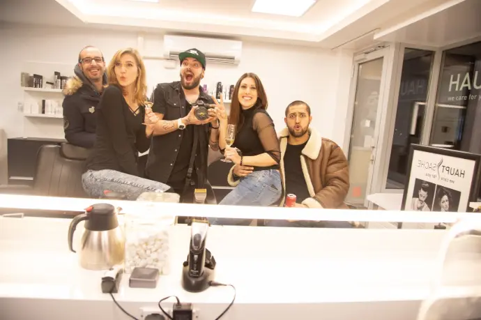 Das Team von Coiffeur HAUPTSACHE posiert mit Freude und Energie in ihrem Salon, während sie gemeinsam eine entspannte Atmosphäre genießen